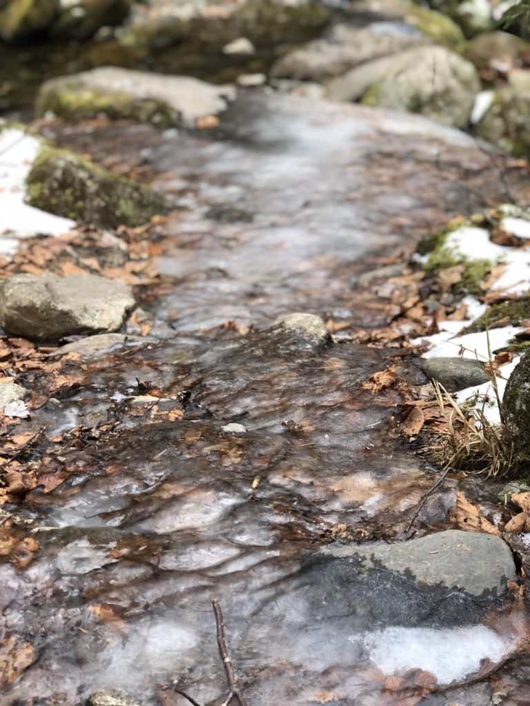 A frozen stream running over rocks, seen while hiking Mt Abraham in the Western Maine Mountains