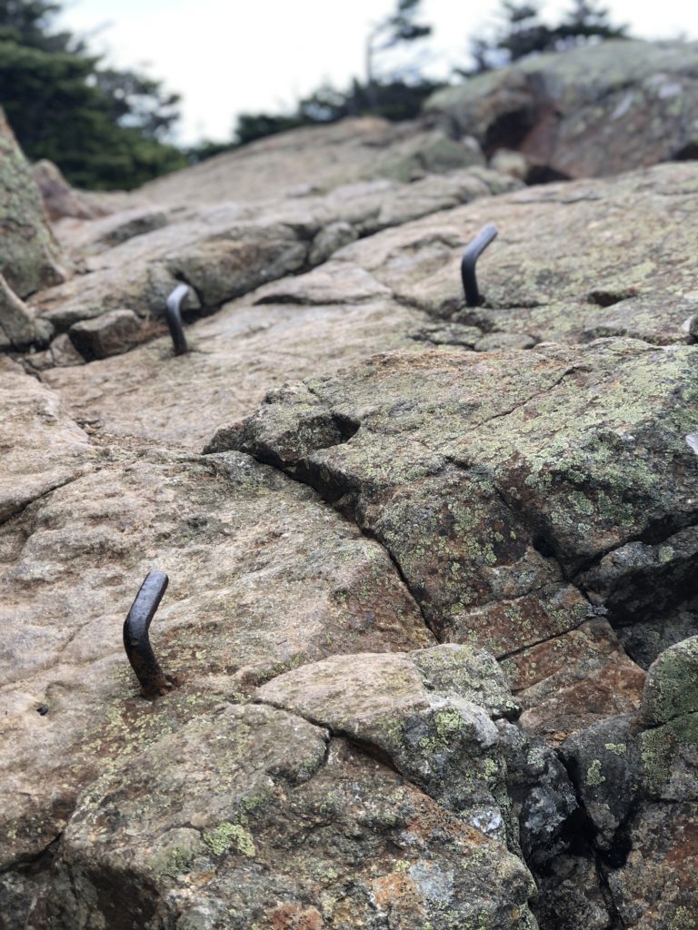 Iron pegs in a boulder seen while hiking Mt Monroe and Mt Washington in the White Mountains, New Hampshire