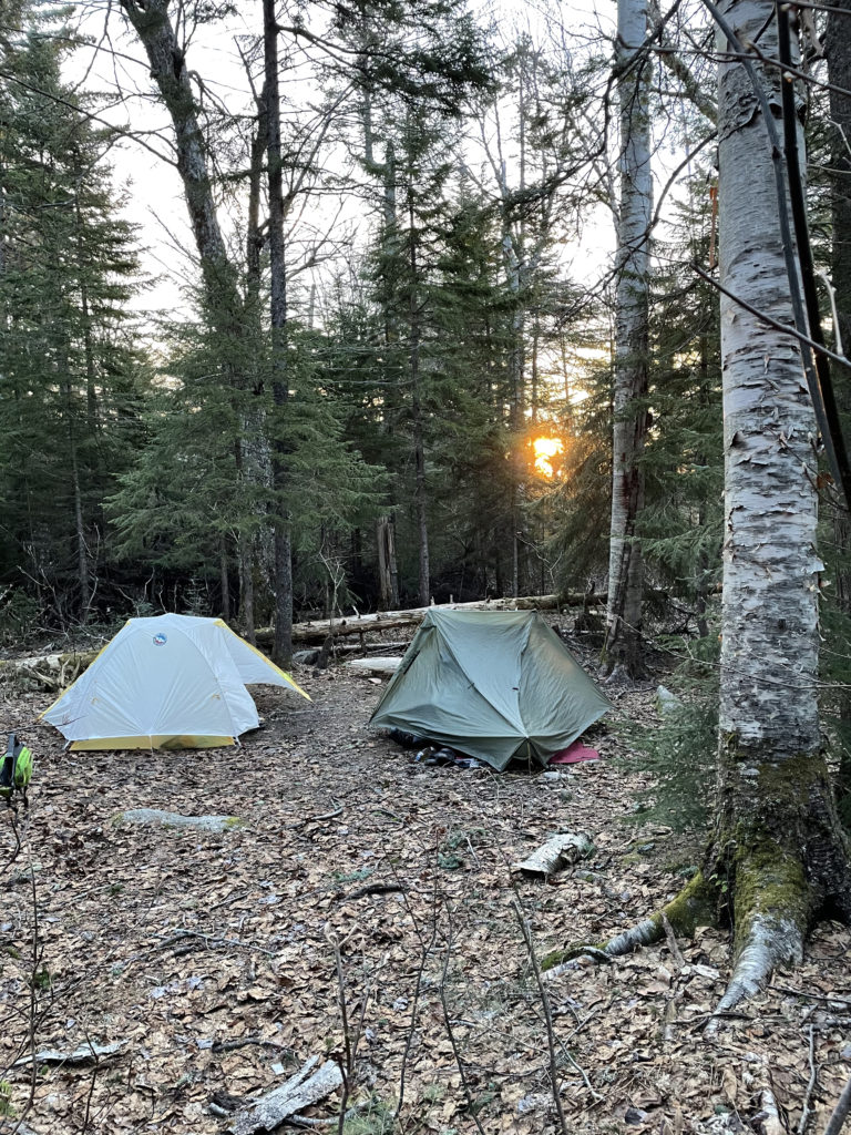 Sunrise behind tents at Baldpate tent site while hiking and backpacking the Grafton Notch Loop Trail in the White Mountains, Maine